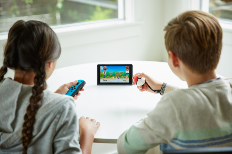 Official imagery of the new Let’s Go Pokémon game. The kid on the right is using the game’s surprisingly comfortable optional Pokéball controller.